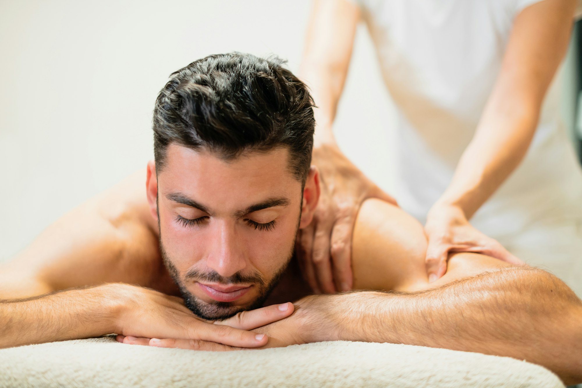 Relaxing young man on massage table in spa